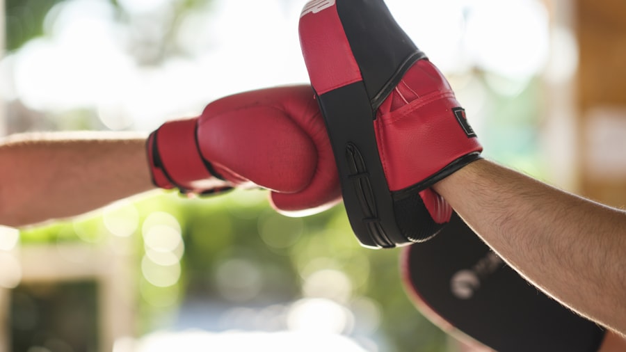 Close-up of a boxing glove striking a focus mitt mid-drill