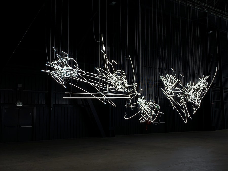 Afterimage Notes: loops of fine white filament suspended in a blacked-out room, drawn out like a line held in the eye.