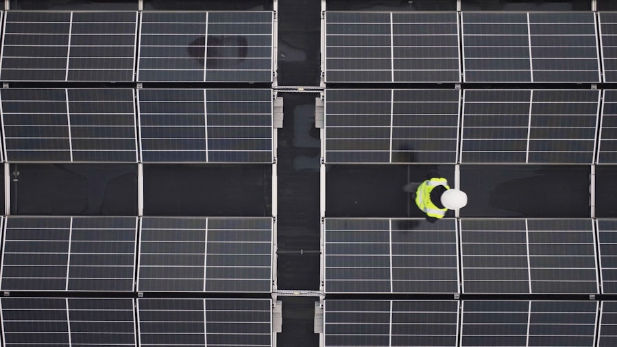 Aerial view of a rooftop solar array with a SolarPeak technician inspecting a panel row