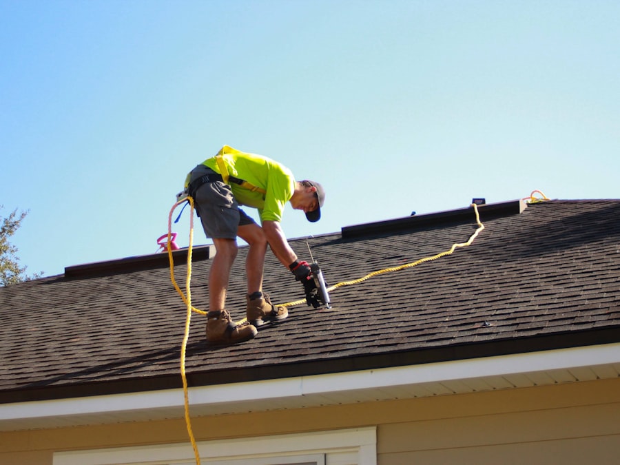SolarPeak technician bent over a shingled roofline sealing a mounting point, safety harness rope visible